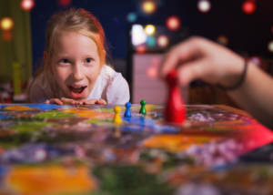 a young girl smiling while playing a board game